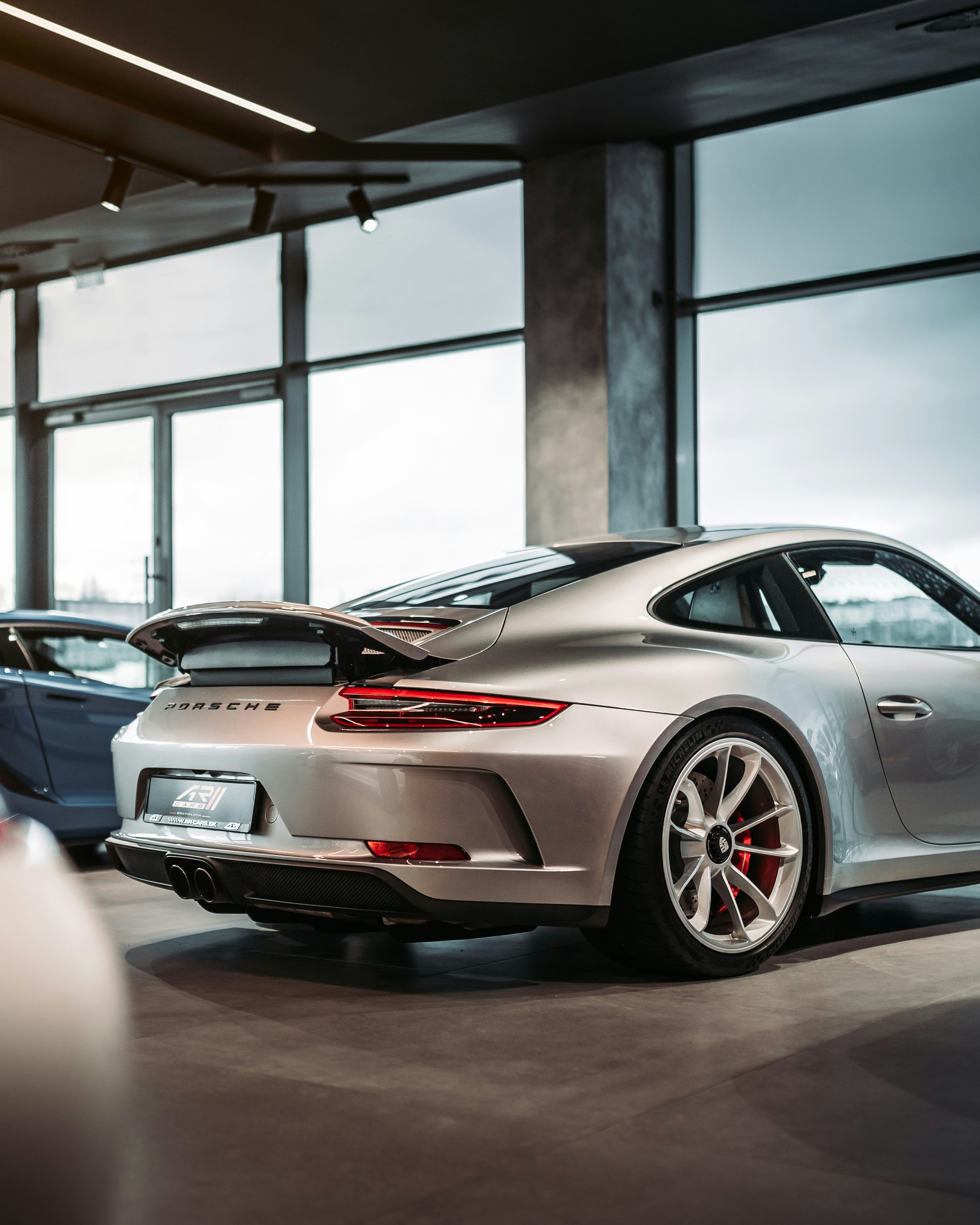 red and black porsche 911 parked in a room